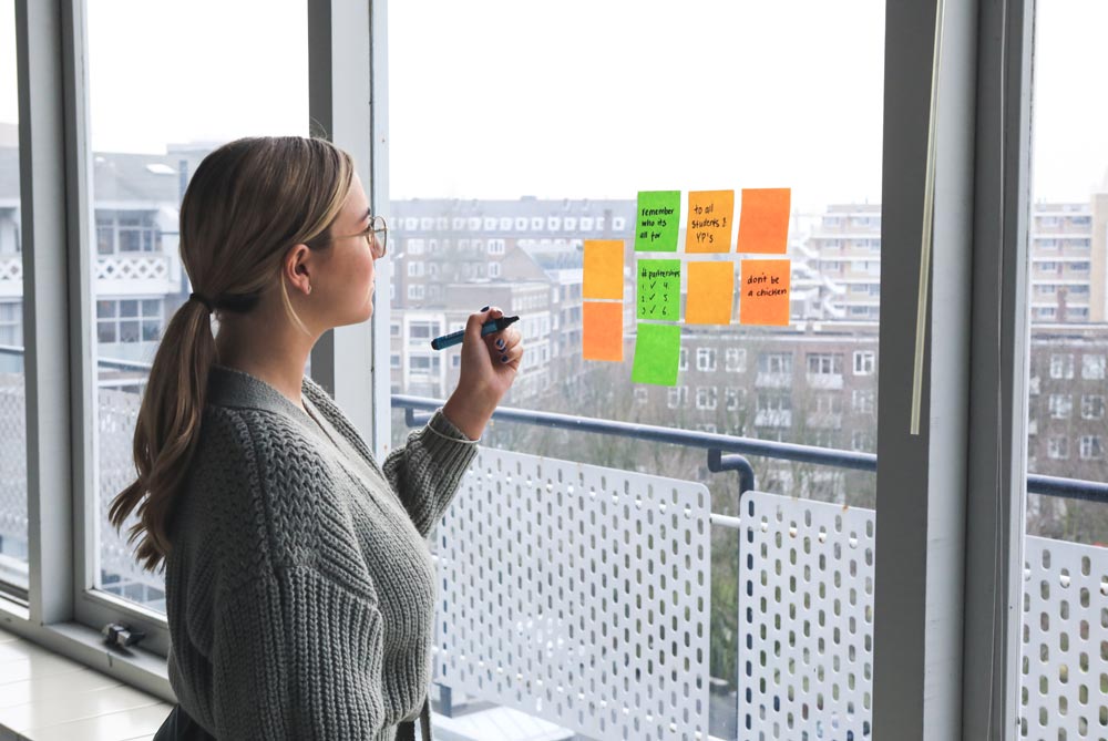 woman writing notes on a window