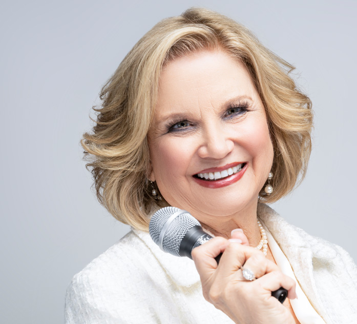 keynote public speaker smiling while holding a microphone