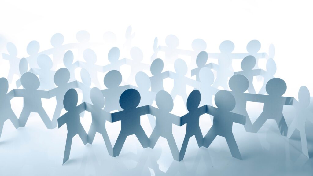 June 2025 Newsletter Image Paper cutout figures in a circle representing teamwork and leading with empathy in a diverse workplace